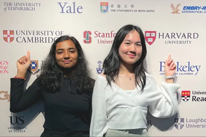 Two students in front of a backdrop of the world's top ranked universities