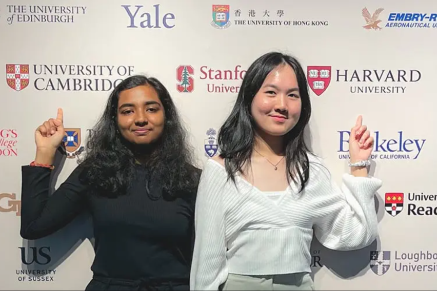 Two students in front of a backdrop of the world's top ranked universities