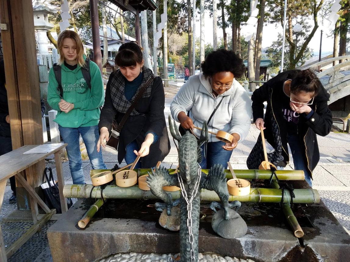 students drink water at a temple in Japan