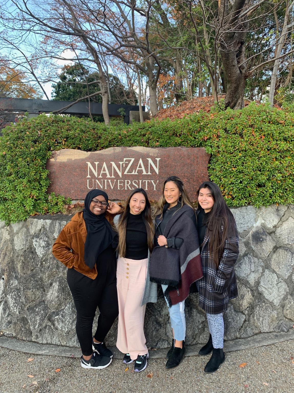 students pose for a photo in front of the Nanzan University sign in Nagoya