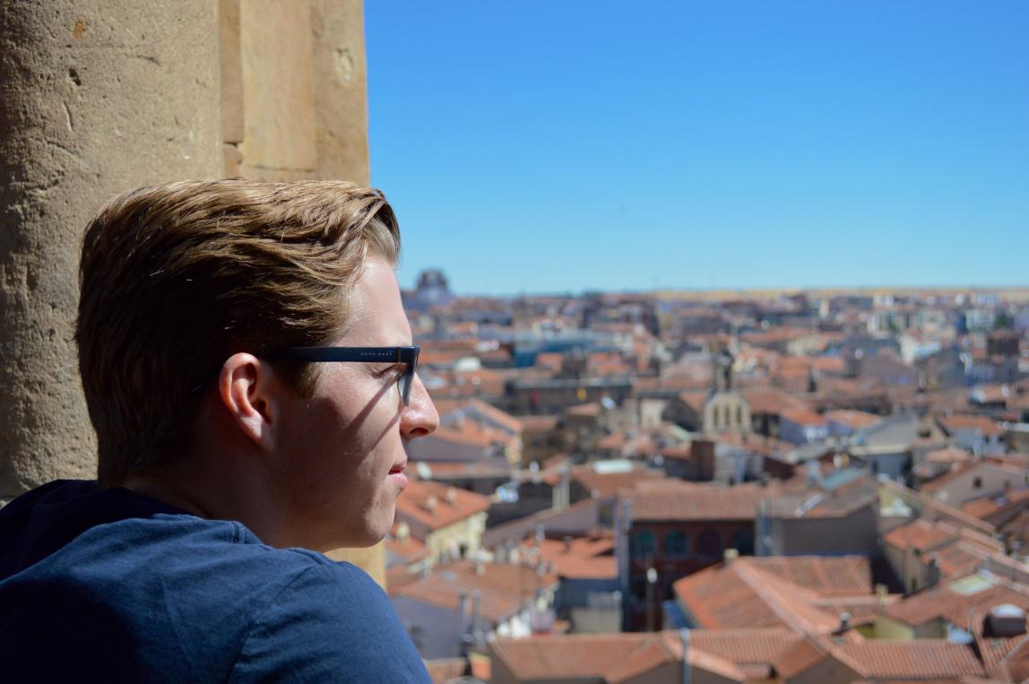 a student looking out over Salamanca from the rooftops