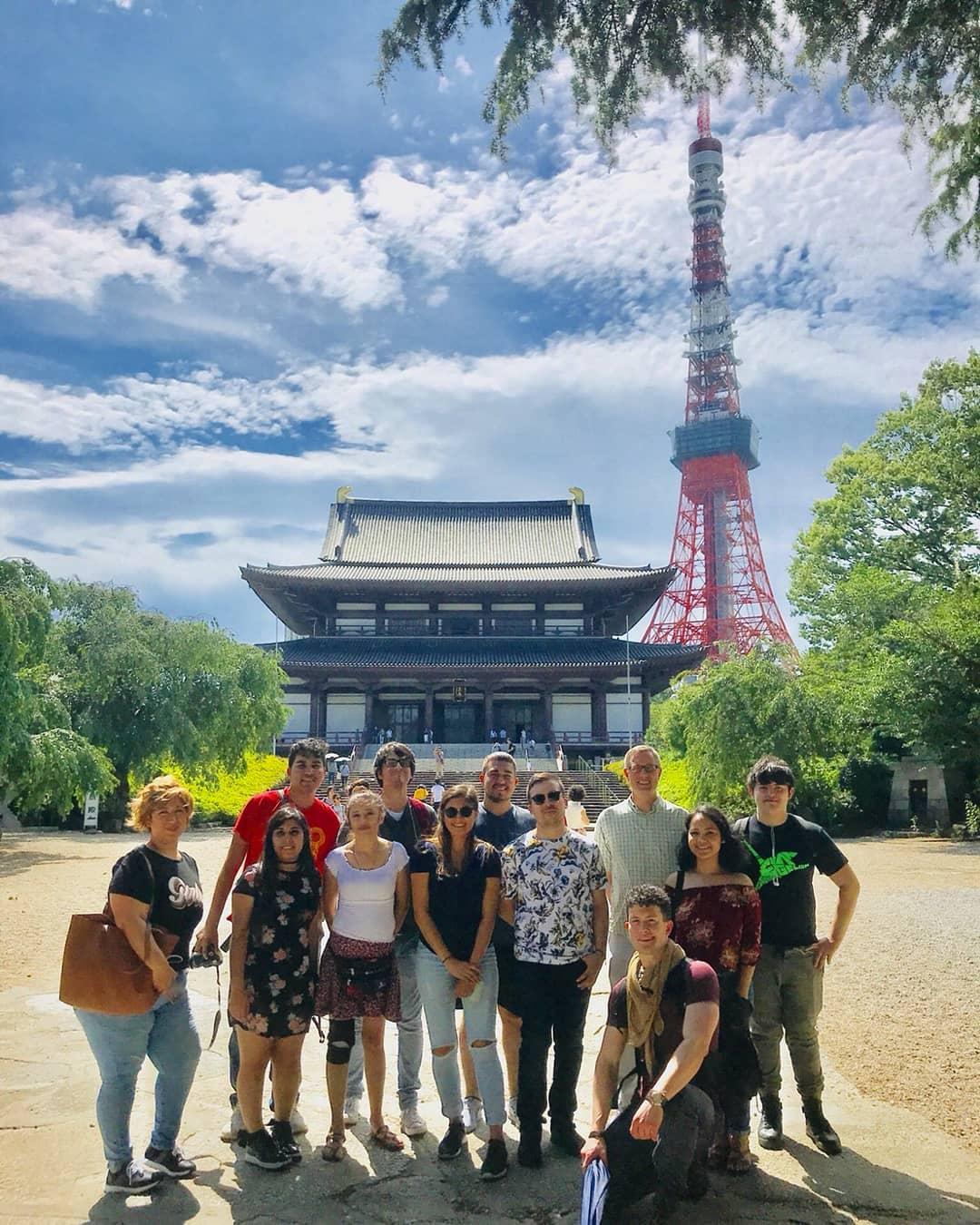 A group of students post in front of a Tokyo monument