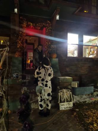 a student dressed in a cow costume going trick-or-treating