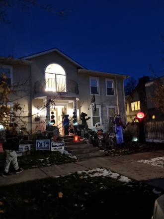 The front of a house covered in Halloween decorations at night