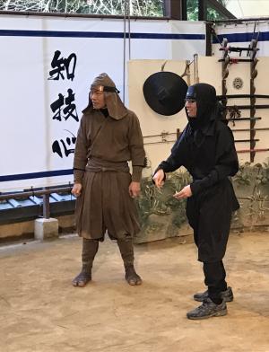 Actors dressed in historical ninja garb performing stunts with a variety of weapons and moves.