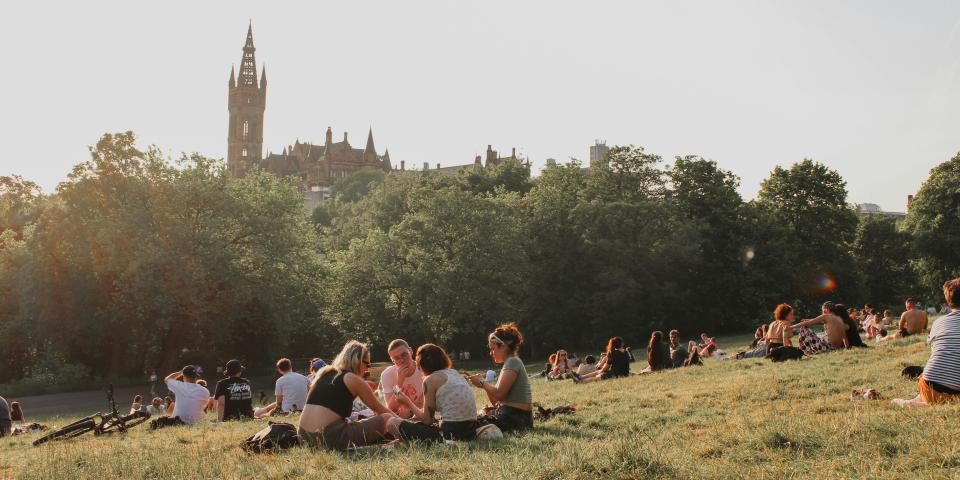 A group of students sits outside at Kelvingrove Park near University of Glasgow