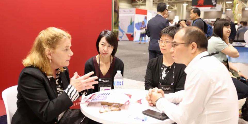 Women and men around a table discussing interational education at NAFSA 